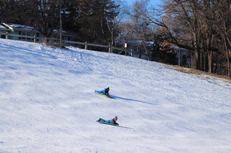Two kids sledding down the hill at Brookside Park