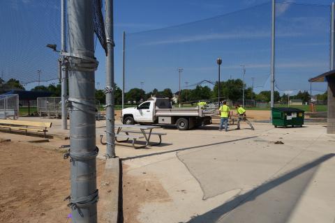 Workers hauling away old fence materials during Dred Fence Replacement August 2022