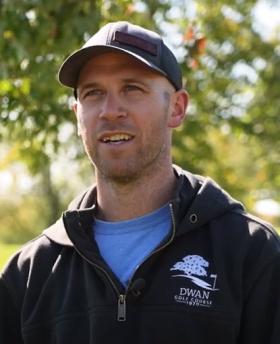 Headshot of Dwan Golf Course Assistant Superintendent Jason Raabe wearing a city logo hat and jacket outside on a sunny day