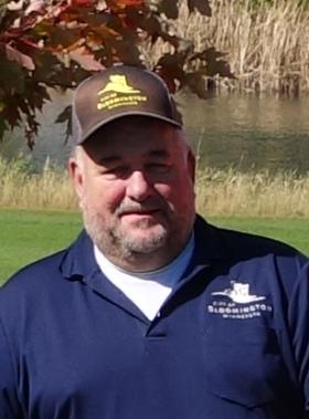 Headshot of Dwan Golf Course Superintendent Jim Riekena wearing a city logo hat and shirt outside on a sunny day