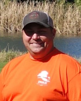 Headshot of Dwan Golf Course maintenance worker and mechanic Steve Mattson wearing a hat and city logo shirt outdoors on a sunny day