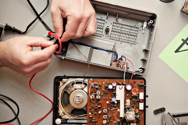 hands mending electronics