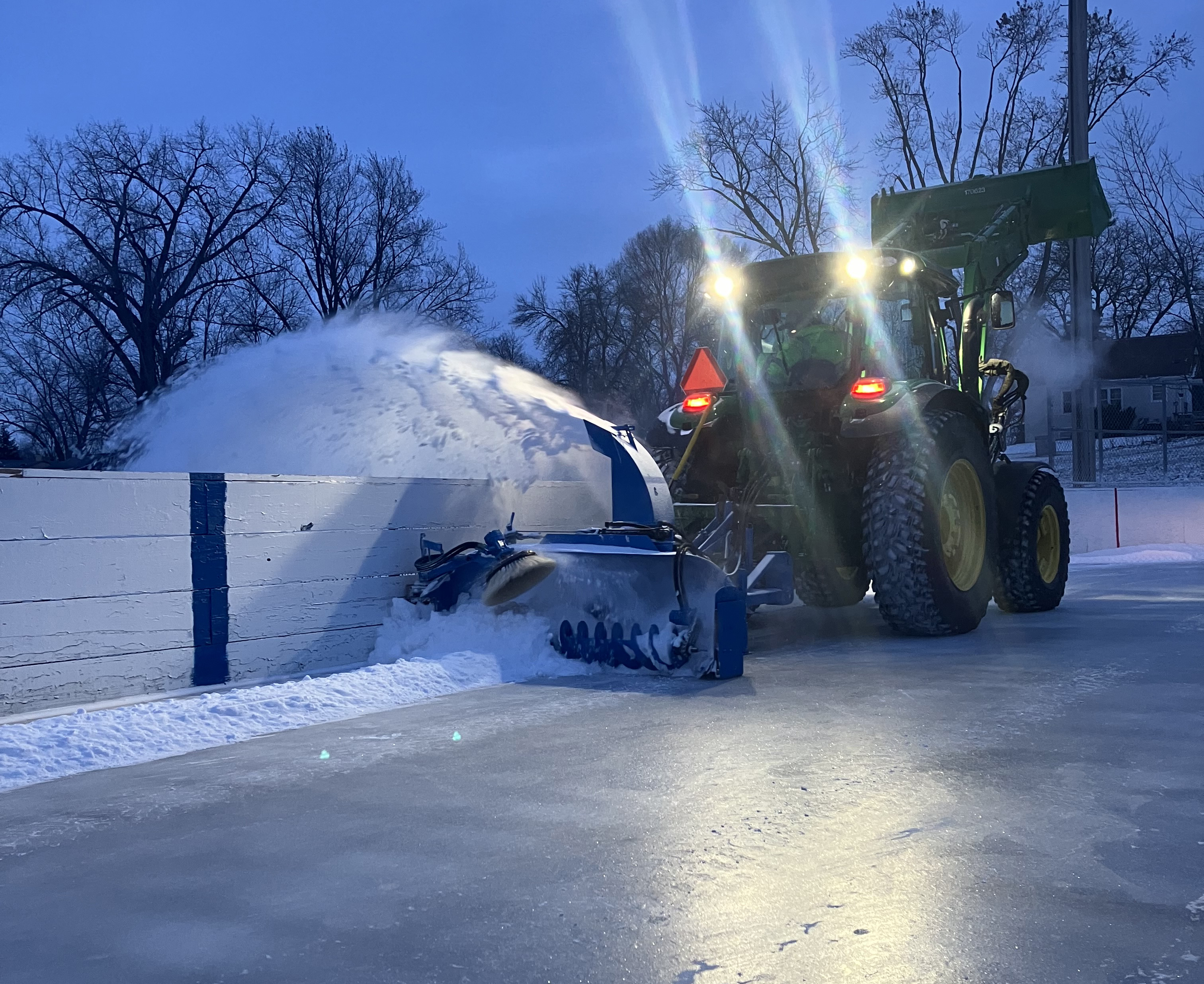 Tractor getting outdoor ice rinks ready for use in January 2024