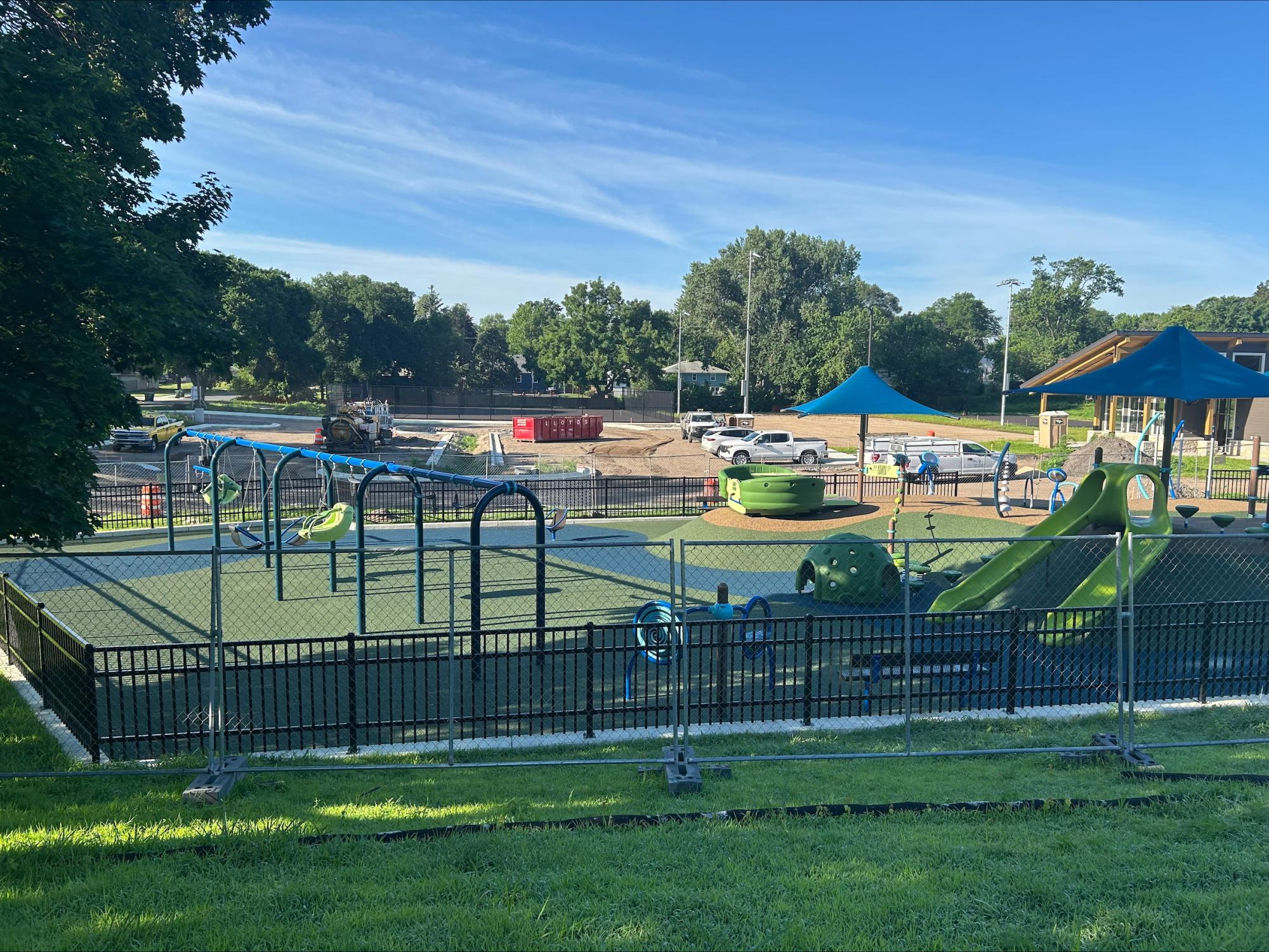 Bryant Park Construction July 8 2025: View of new inclusive playground with brightly colored blue and green apparatus including swings and slides
