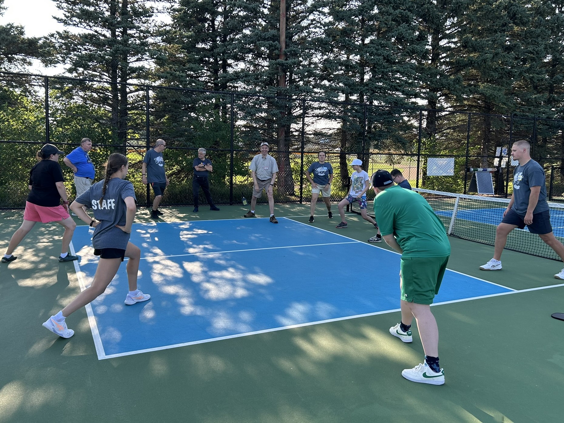 Adults stretching and warming up on a racquet court