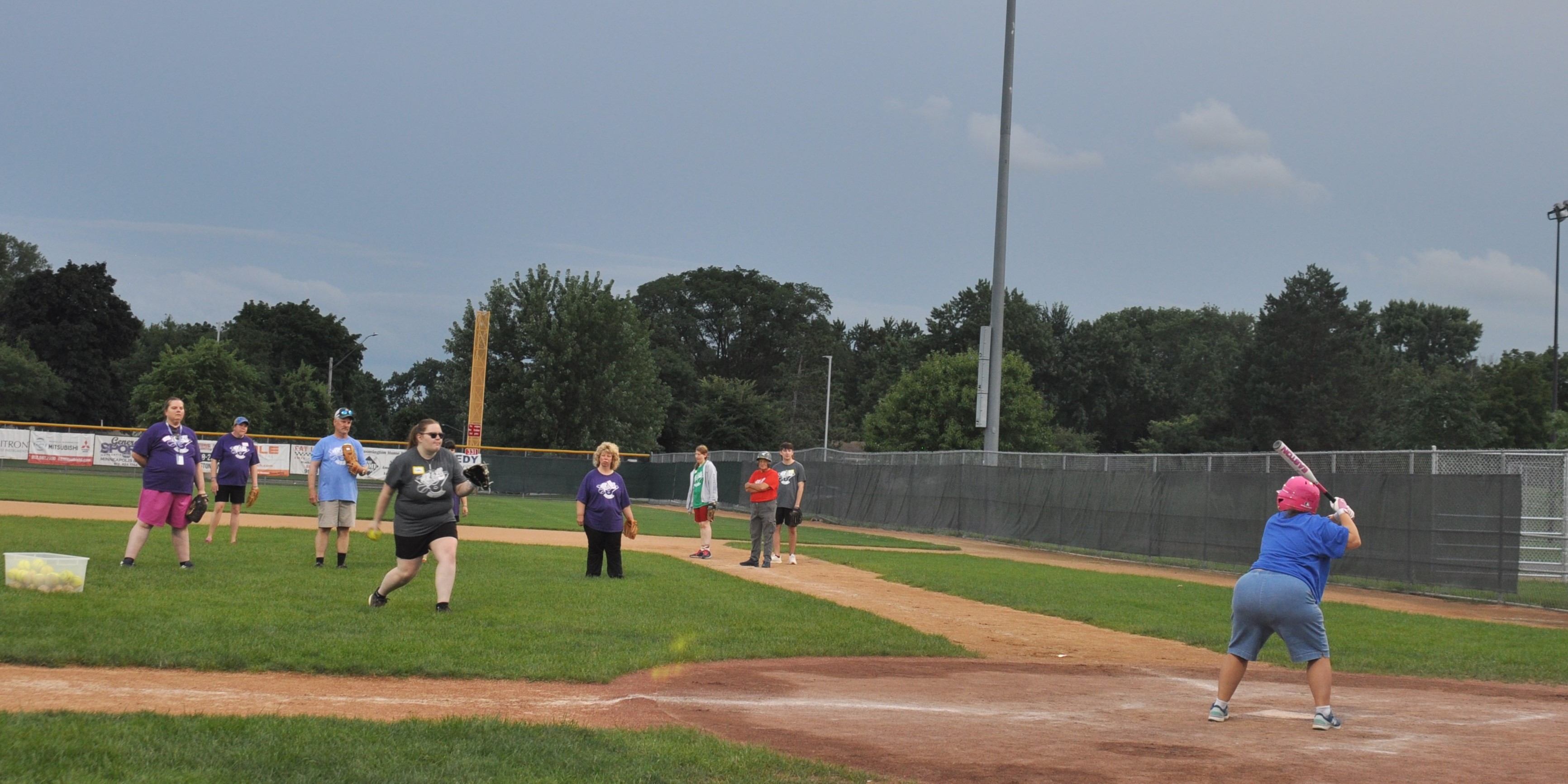 adults with disabilities playing softball outdoors