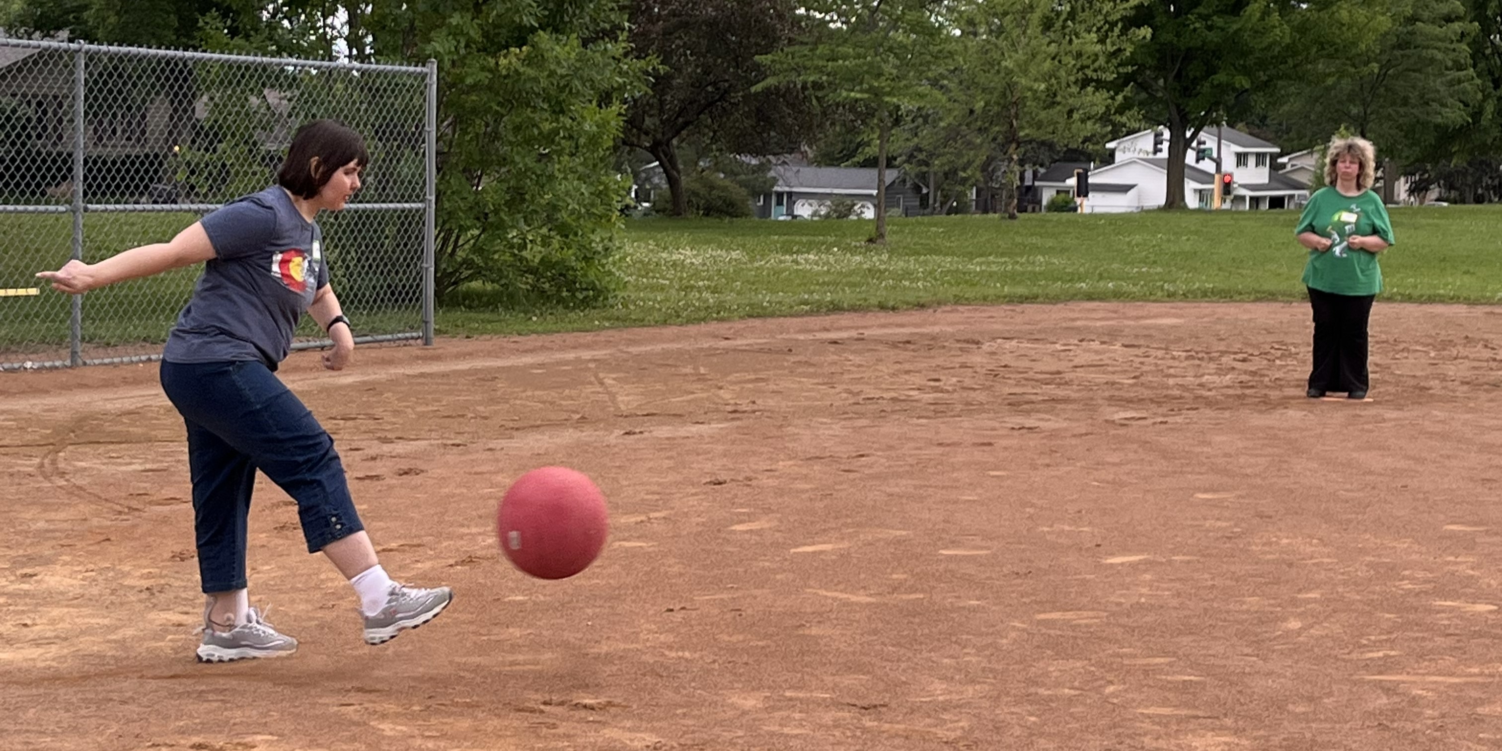Photo of adaptive recreation participant playing kickball outdoors