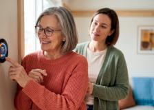 Senior woman adjusting a thermostat