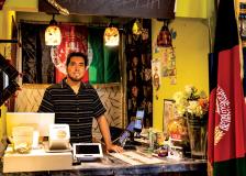 Rizwan Qazizada, owner of Afghan Darbar, stands at the front counter in his restaurant.