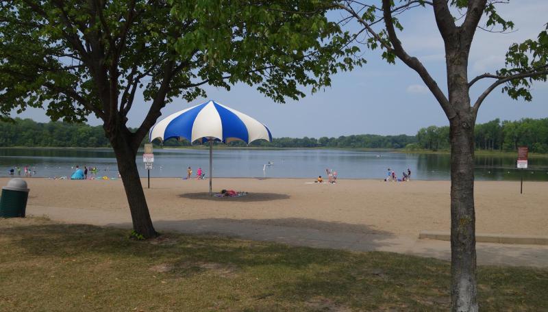 Bush Lake Beach swimmers, kayaks, large umbrella