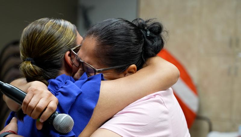 Two community members share a hug