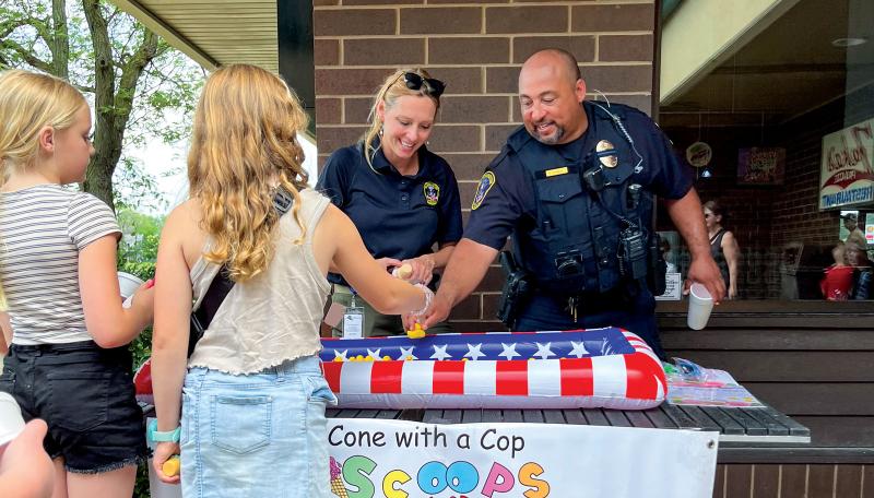 Bloomington Police staff and officers speak with community members at a Cops and Cones event in 2025.