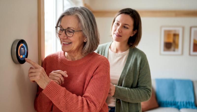 Senior woman adjusting a thermostat