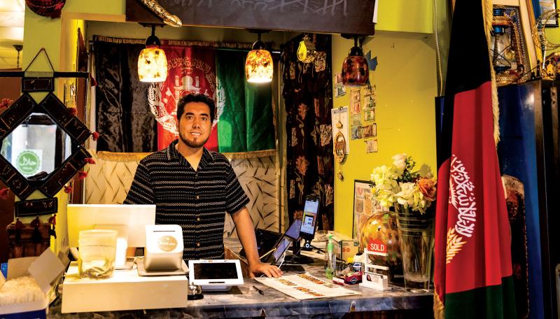 Rizwan Qazizada, owner of Afghan Darbar, stands at the front counter in his restaurant.