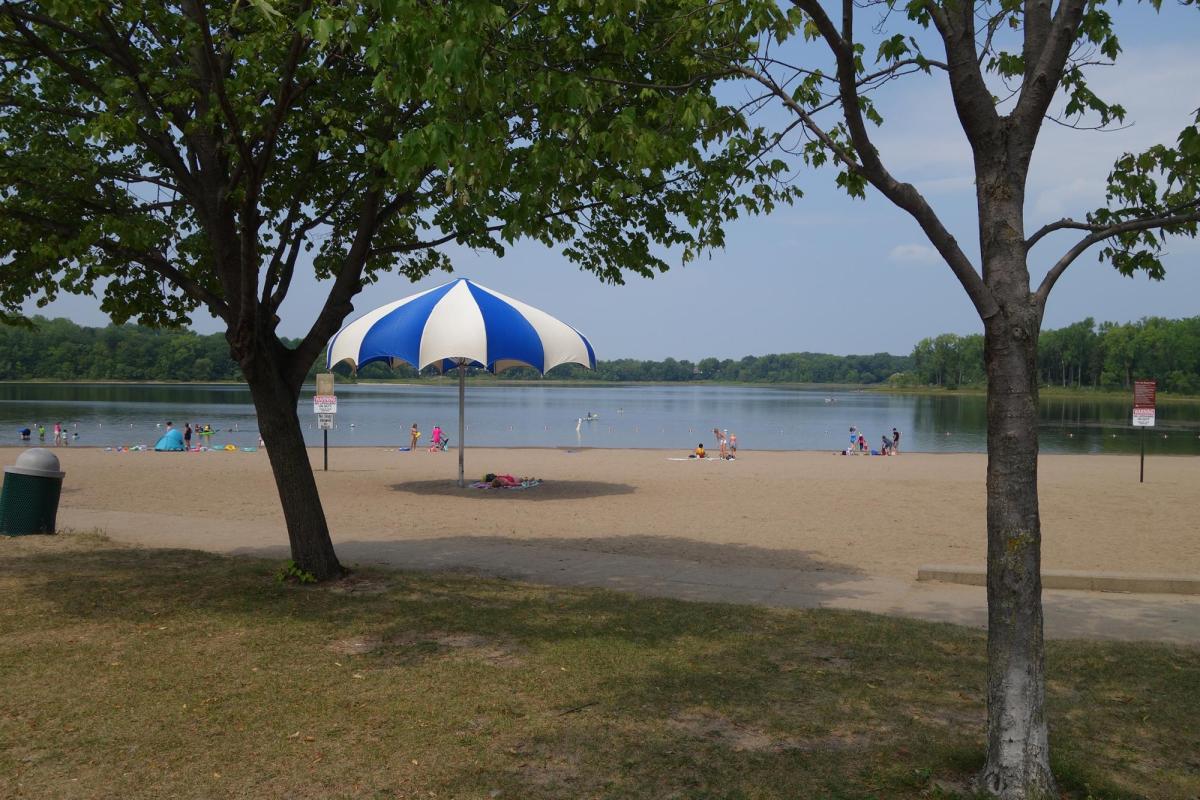 Bush Lake Beach swimmers, kayaks, large umbrella