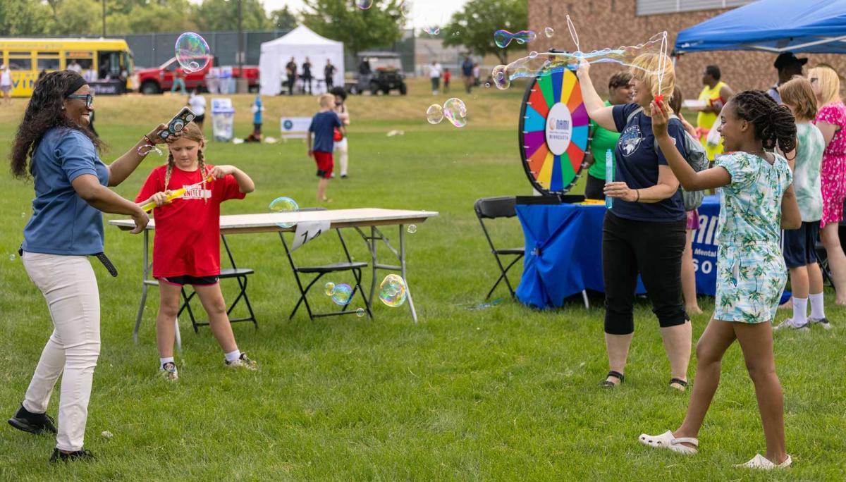 people blowing soap bubbles and having fun outdoors