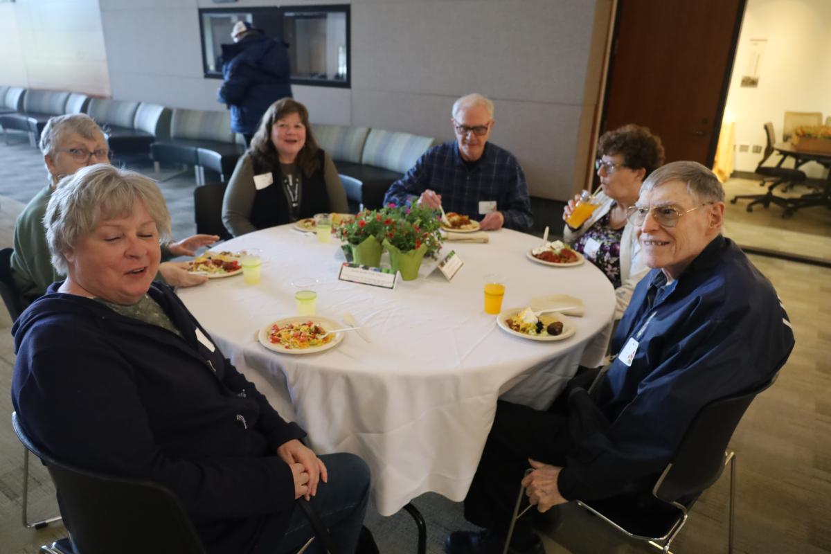 A group of adults sit around a table at the Volunteer Appreciation Event.