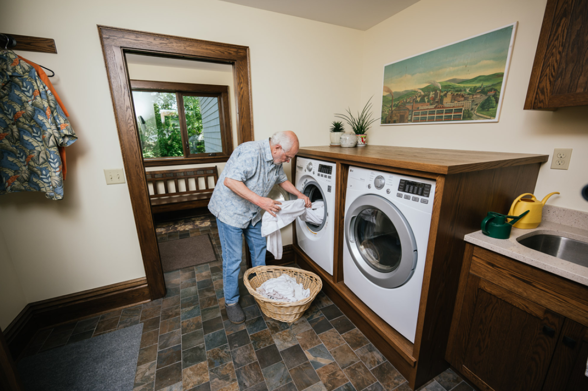 Person putting clothes in an electric resistance dryer