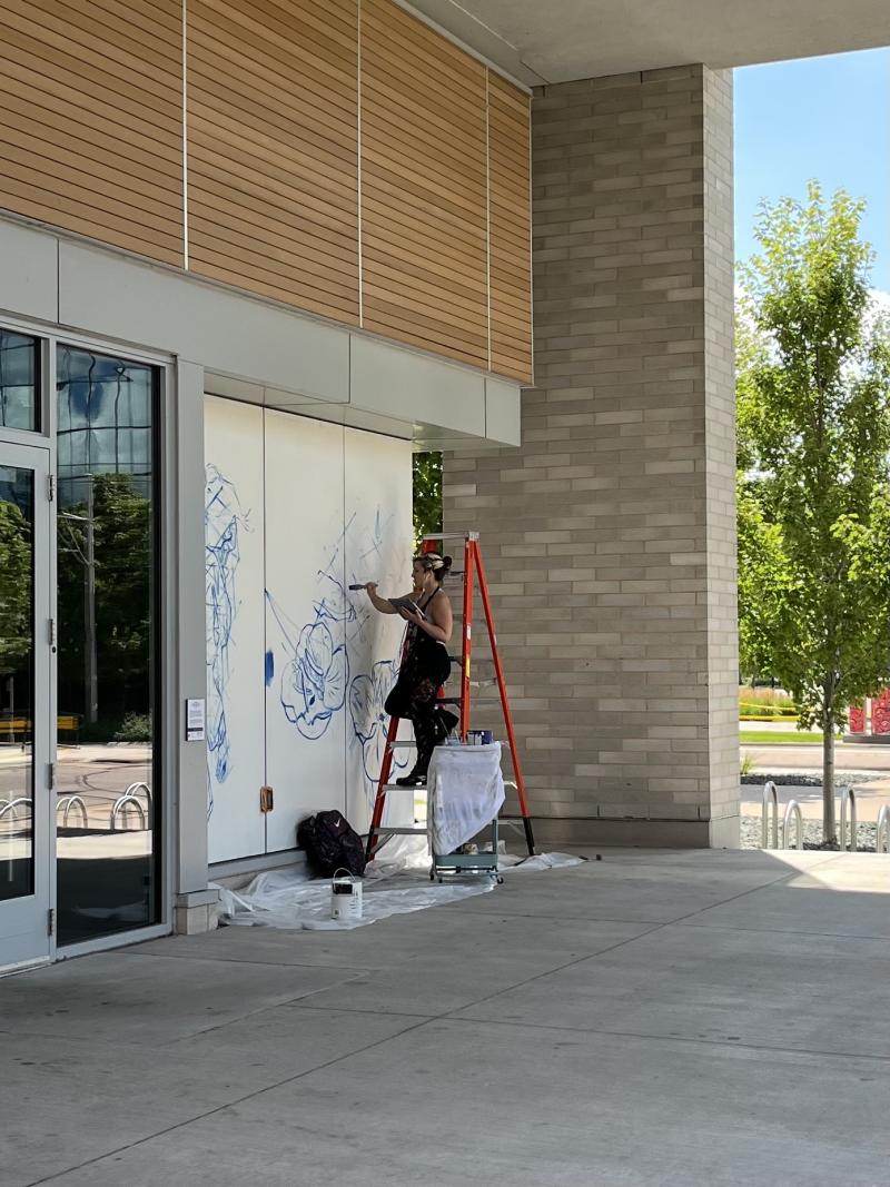 Artist Mariela Ajras at work on Fenley Apartment Mural
