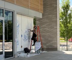 Artist Mariela Ajras at work on Fenley Apartment Mural