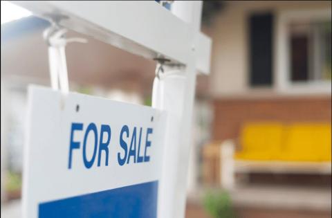Blue and white for sale sign in front of house