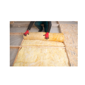 person rolling out yellow insulation with red gloves