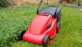 Red lawnmower on green grass